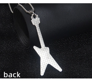 Détail du dos d'un pendentif guitare argenté montrant la texture étoilée en métal