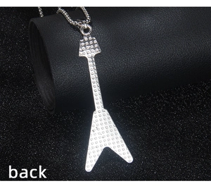 Detail showing the floral engraved pattern on the back of the silver guitar pendant