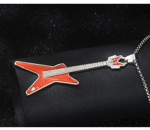 Vue macro d'un pendentif guitare rouge avec émail et détails de la chaîne en métal argenté