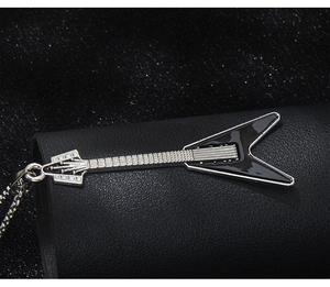 Macro shot of Flying V electric guitar pendant with black enamel finish on leather