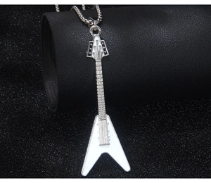 Macro detail of silver Flying V guitar pendant with white enamel on a metal chain link