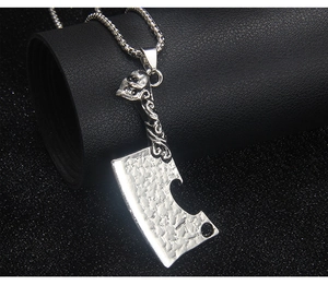 Detailed macro shot of punk style cleaver pendant with skull carving on steel chain
