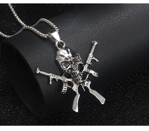 Vue macro d'un pendentif tête de mort gothique avec fusils croisés sur fond noir texturé
