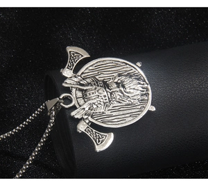 Close-up of Viking double axe pendant with bearded warrior relief on black leather