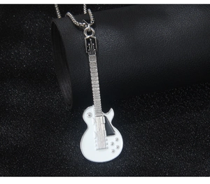 Gros plan détaillé du pendentif guitare électrique blanche sur une chaîne argentée