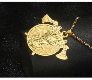 Close-up of golden Viking warrior pendant with double axes on a black leather display