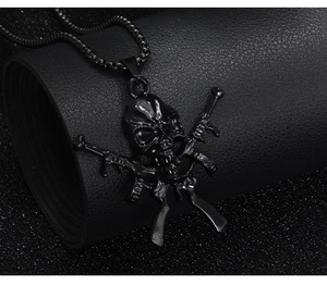 Pendentif tête de mort gothique punk avec fusils croisés sur une chaîne à billes noire