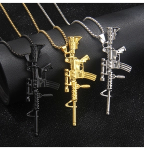 Detail view of rifle shaped pendants in gold black and silver with bead chains