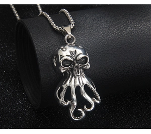 Close-up of vintage silver octopus skull pendant with long tentacles on a metal chain