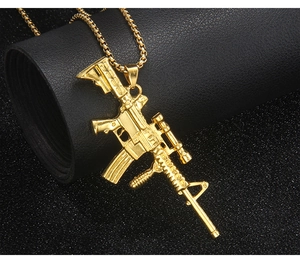 Detailed close-up of a golden metal rifle pendant on a classic round box chain necklace