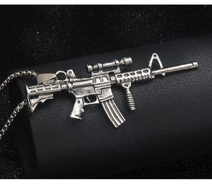 Macro detail of vintage silver stainless steel rifle pendant necklace with rifle scope