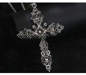 Vue macro du dos d'un grand pendentif croix gothique ajouré en argent vintage
