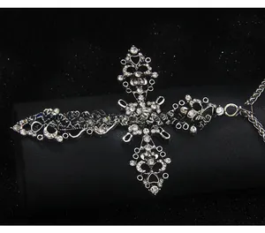 Détail d'un collier croix punk gothique argenté avec pavage de cristaux brillants