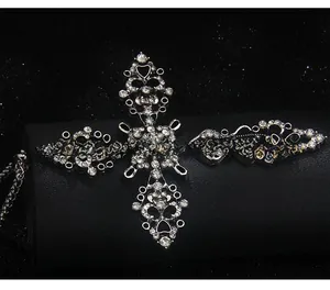 Détail du collier croix gothique argentée avec cristaux pavés et motifs de vigne