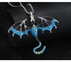 Macro detail of gothic dragon pendant with blue enamel wings and colorful rhinestones