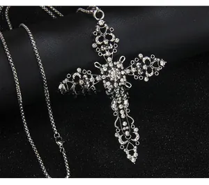 Vue macro d'un pendentif croix vintage en argent avec strass blancs et détails ciselés
