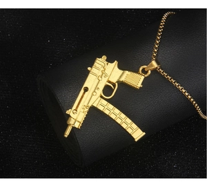 Makroaufnahme des goldenen Maschinenpistole-Anhängers im Hip-Hop-Stil auf Zylinder