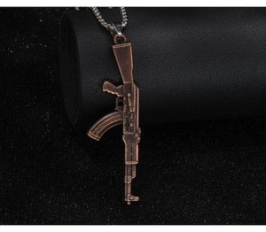 Macro shot of vintage bronze AK-47 rifle pendant with intricate textures on leather