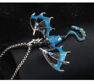 Macro shot of gothic dragon necklace with blue rhinestones and colorful enamel wings