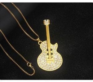 Detailed macro view of a gold guitar pendant necklace with pavé cubic zirconia crystals