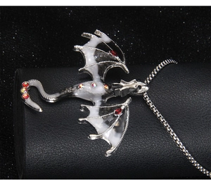 Macro shot of gothic dragon necklace pendant with black and white enamel and red crystals