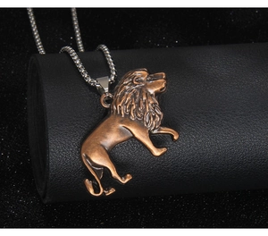 Macro shot of vintage bronze lion pendant with silver stainless steel box chain necklace