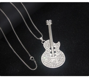 Detailed macro view of silver guitar pendant with sparkling rhinestones and chain