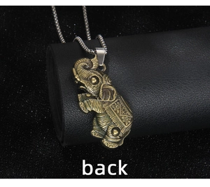 Detail view of the back side of a vintage bronze elephant pendant with carved patterns