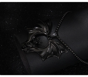 Macro shot of dark bat necklace featuring intricate cutout details and a black metal finish