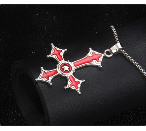 Macro view of gothic inverted cross pendant with red enamel inlay and silver chain detail