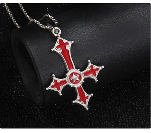 Detailed view of Gothic inverted cross pendant with red enamel and star on leather roll