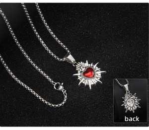 Dettaglio macro della collana gotica in acciaio inossidabile con cuore rosso