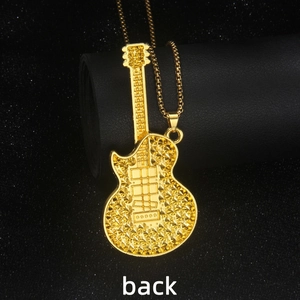 Gold-plated electric guitar necklace with studded texture on black display stand