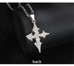 Macro view showing the textured back of a gothic silver cross pendant with a link chain