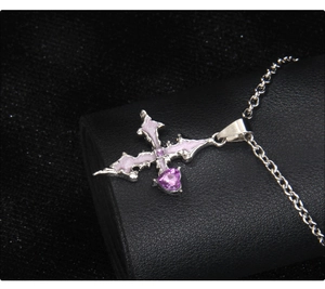 Detailed close-up of gothic stainless steel cross necklace with purple heart gemstone
