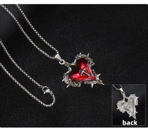 Dettaglio macro della collana gotica con cuore in smalto rosso e pendente a croce