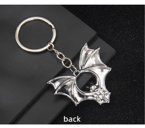 Detail view showing the back of a silver metal bat keychain with a 1982 engraved mark