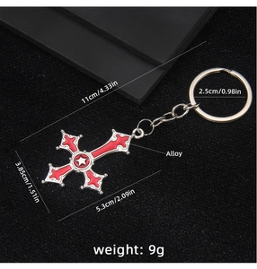 Macro detail of gothic red enamel cross keychain with silver star and alloy chain