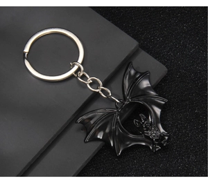 Close-up of gothic black double bat keychain with silver metallic ring and chain detail