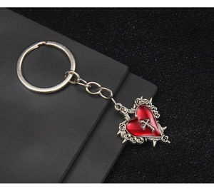 Detail of gothic heart cross keychain with red oil drop heart and silver metal carving