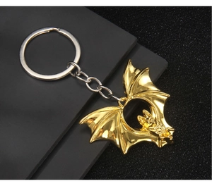 Detail of a vintage golden bat keychain featuring an intricate hollowed winged design