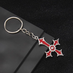 Silver cross keychain with red enamel inlay and star detail on black background