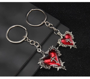 Close-up of gothic silver cross on red resin heart pendant with thorn crown detail