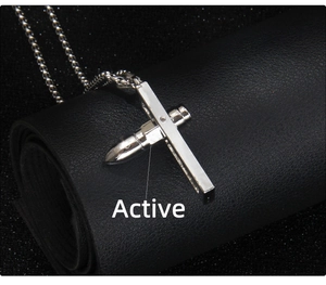 Détail macro du pendentif croix balle argentée sur cuir avec chaîne en acier inoxydable