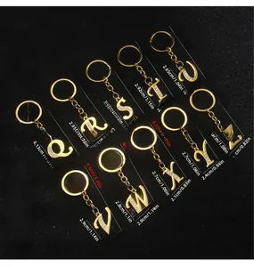 Macro detail of gold-plated alphabet keychains with rhinestones and size measurements