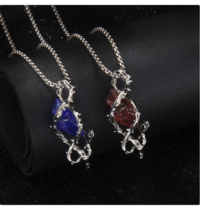 Vue macro des pendentifs cœur gothiques en bleu et rouge avec détails d'épines en métal