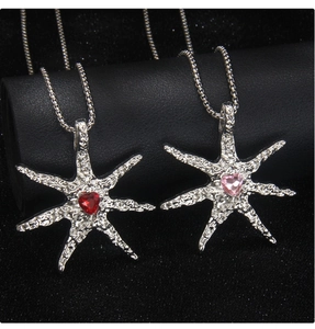 Detail of starfish pendant with heart-shaped gemstone and irregular lava metal texture