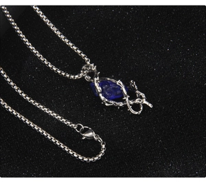 Épines gothiques en argent entourant une pierre de cœur bleue sur une longue chaîne box