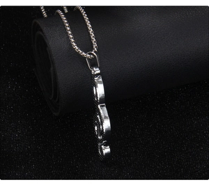 Macro side view showing thickness and fine chain of silver musical note necklace