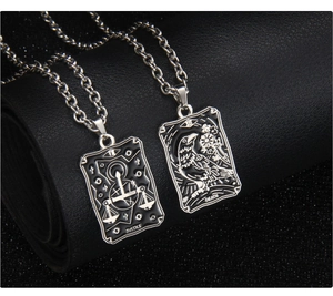 Détail macro des pendentifs de tarot Justice et Mort avec finition en émail noir